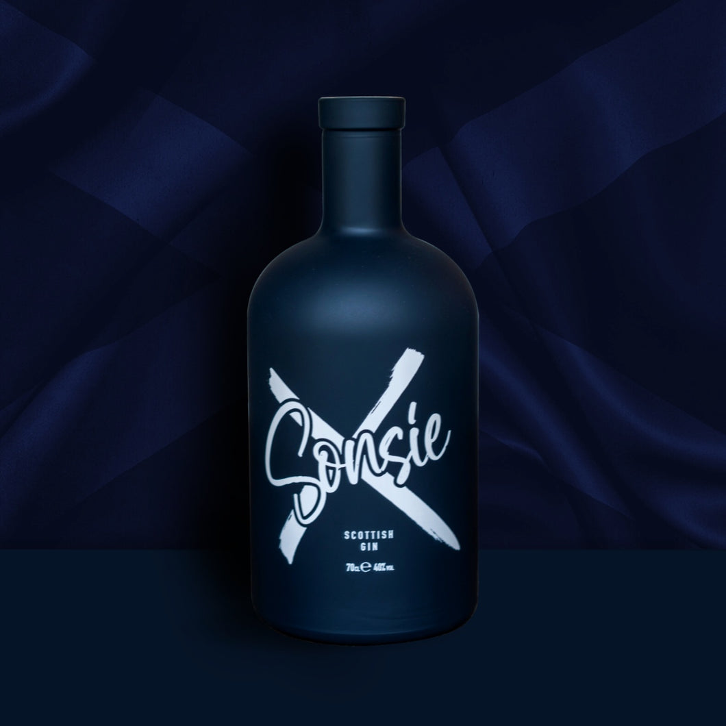 Dark blue, opaque bottle with the word 'Sonsie' in white in cursive letters and a white saltire cross behind. The background is a blue saltire flag.