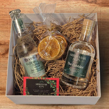 Load image into Gallery viewer, White gift box with a bottle of Fevertree tonic on the left, dried orange slices in the middle and a small bottle of The Cobbler gin on the right. Packing straw behind.
